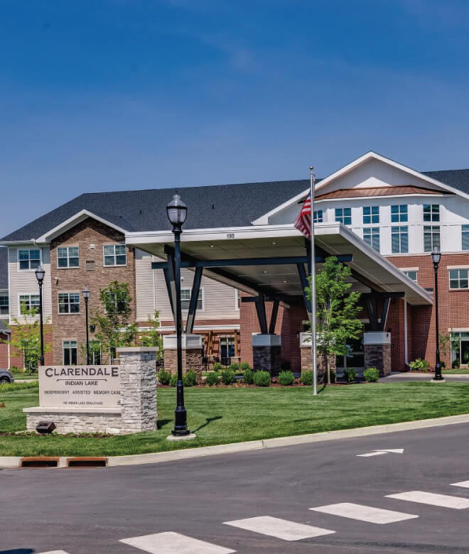Assisted living facility entrance with landscaped grounds and building exterior on a sunny day