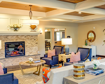 Cozy lobby area with modern furniture and a fireplace, featuring elegant decor and ample seating.