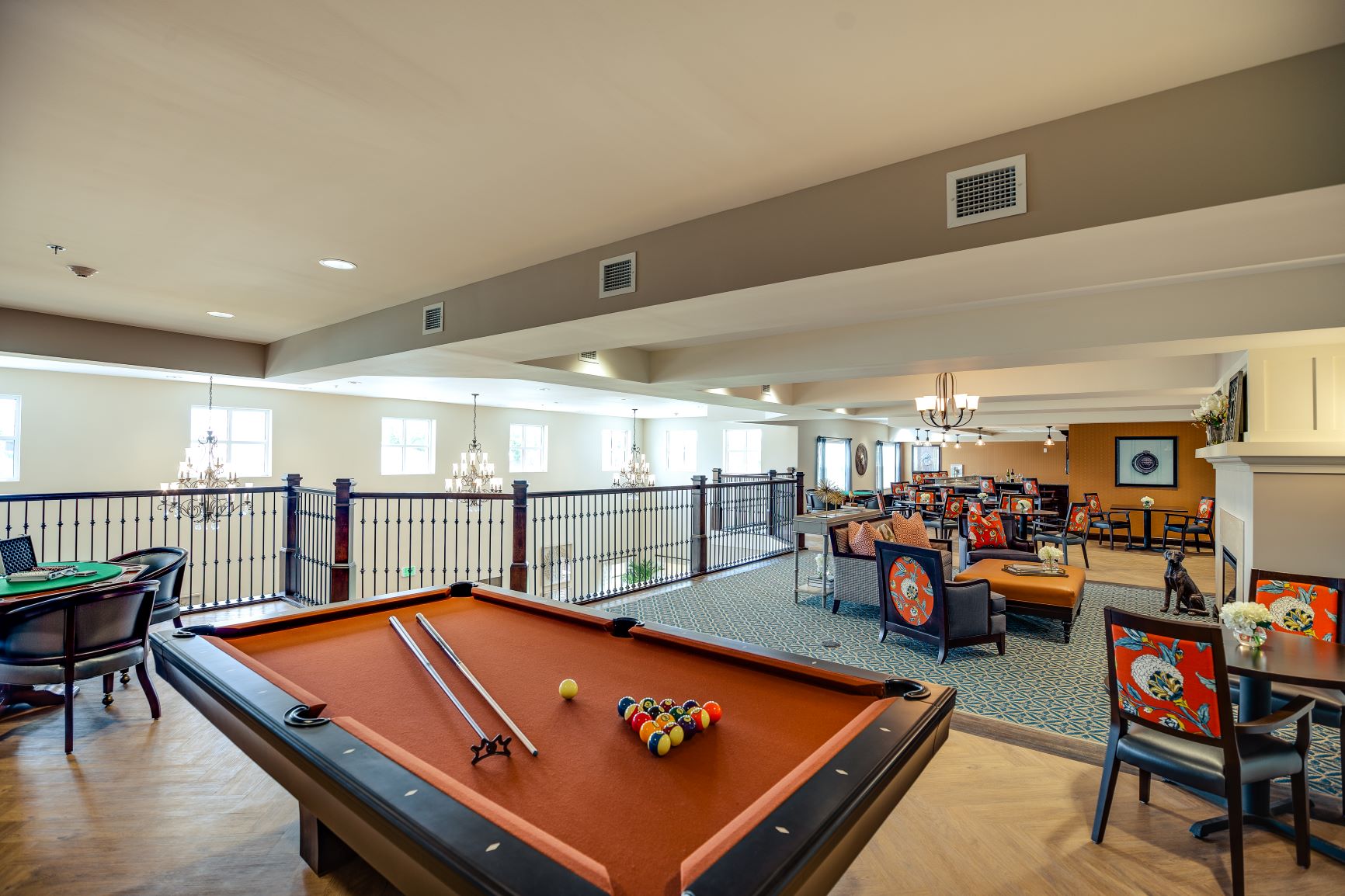 Sophisticated Game Room with Pool Table Elegant room with a pool table, poker table, and seating area decorated with chandeliers.