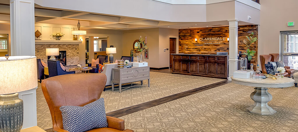 Welcoming lobby area with warm lighting, comfortable seating, and a reception desk with wood paneling.