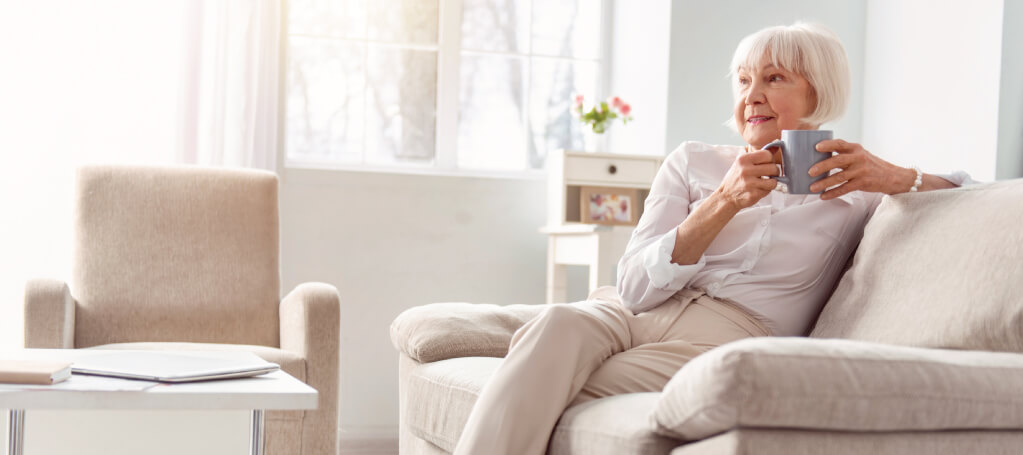 woman enjoying coffee on her couch